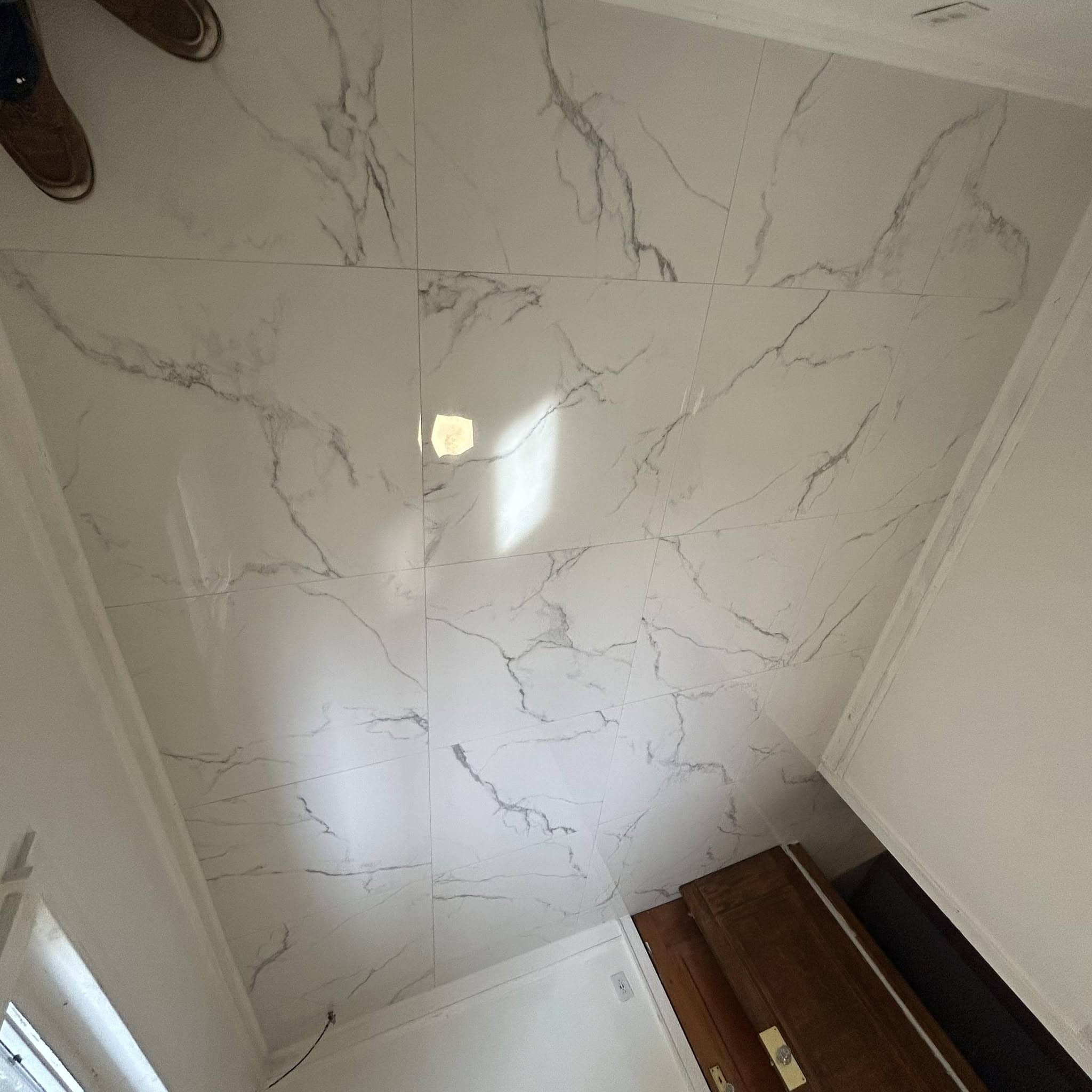 Polished white marble-look tile installed on a wall