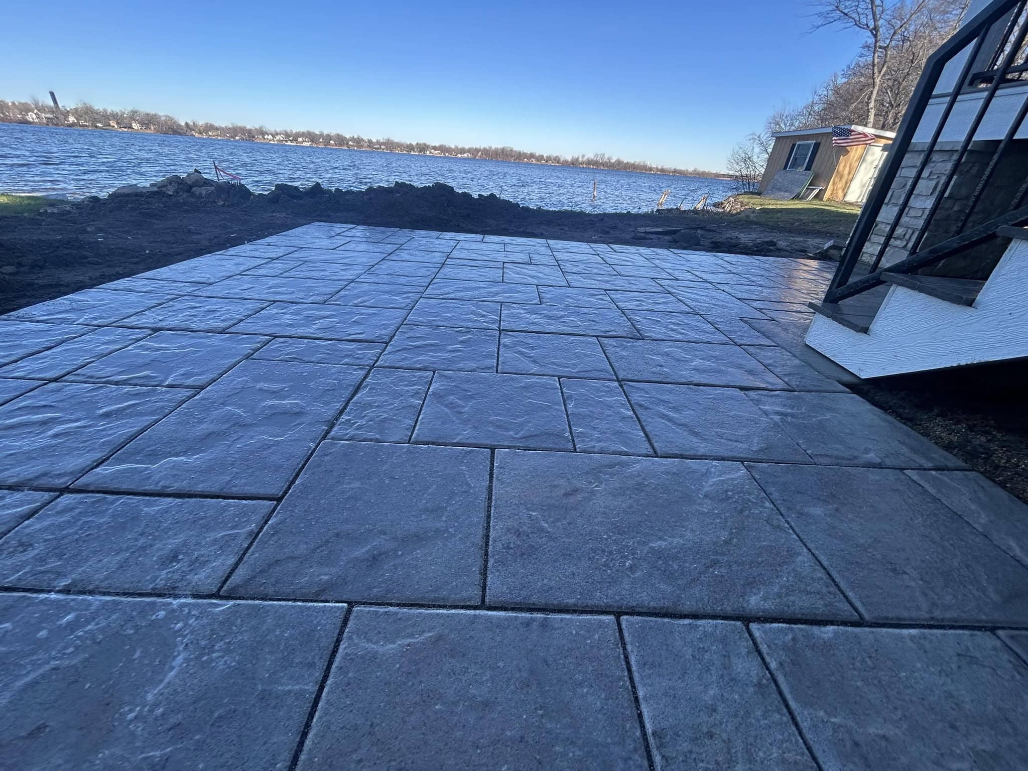 Dark stamped paver patio installed along the waterfront